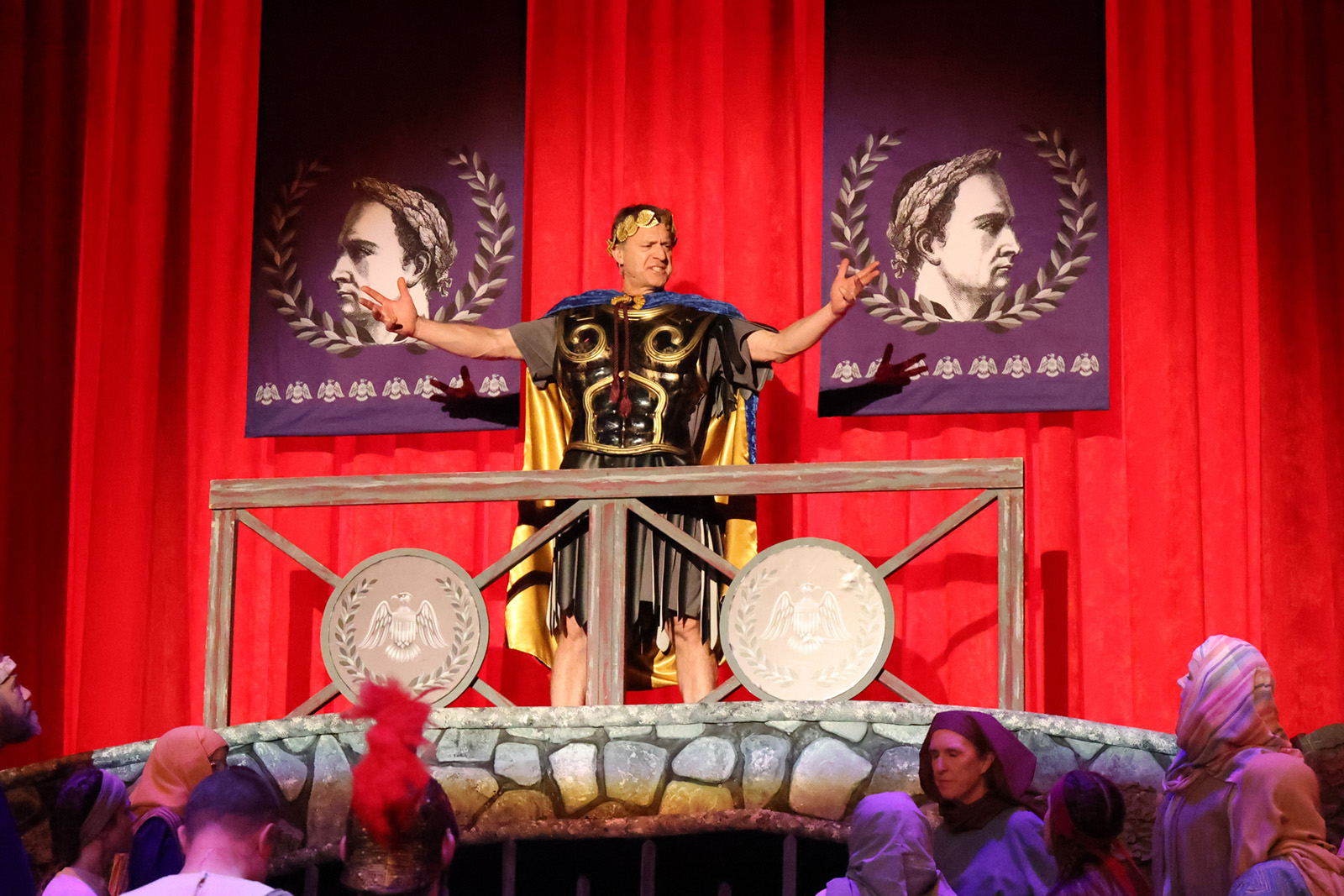 Pilate stands on a raised platform surveying Jesus and crowd who are making angry gestures.